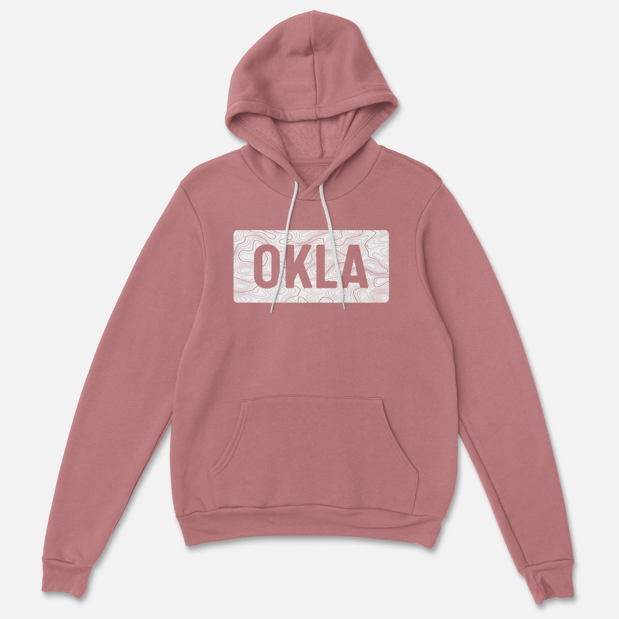 The OKLA Navigator BOLD Hoodie, made from recycled cotton, features a dusty pink color and comes with a front pocket and white drawstrings. Its rectangular pattern highlights the "OKLA" logo amidst a subtle design, perfectly merging adventure with comfort.