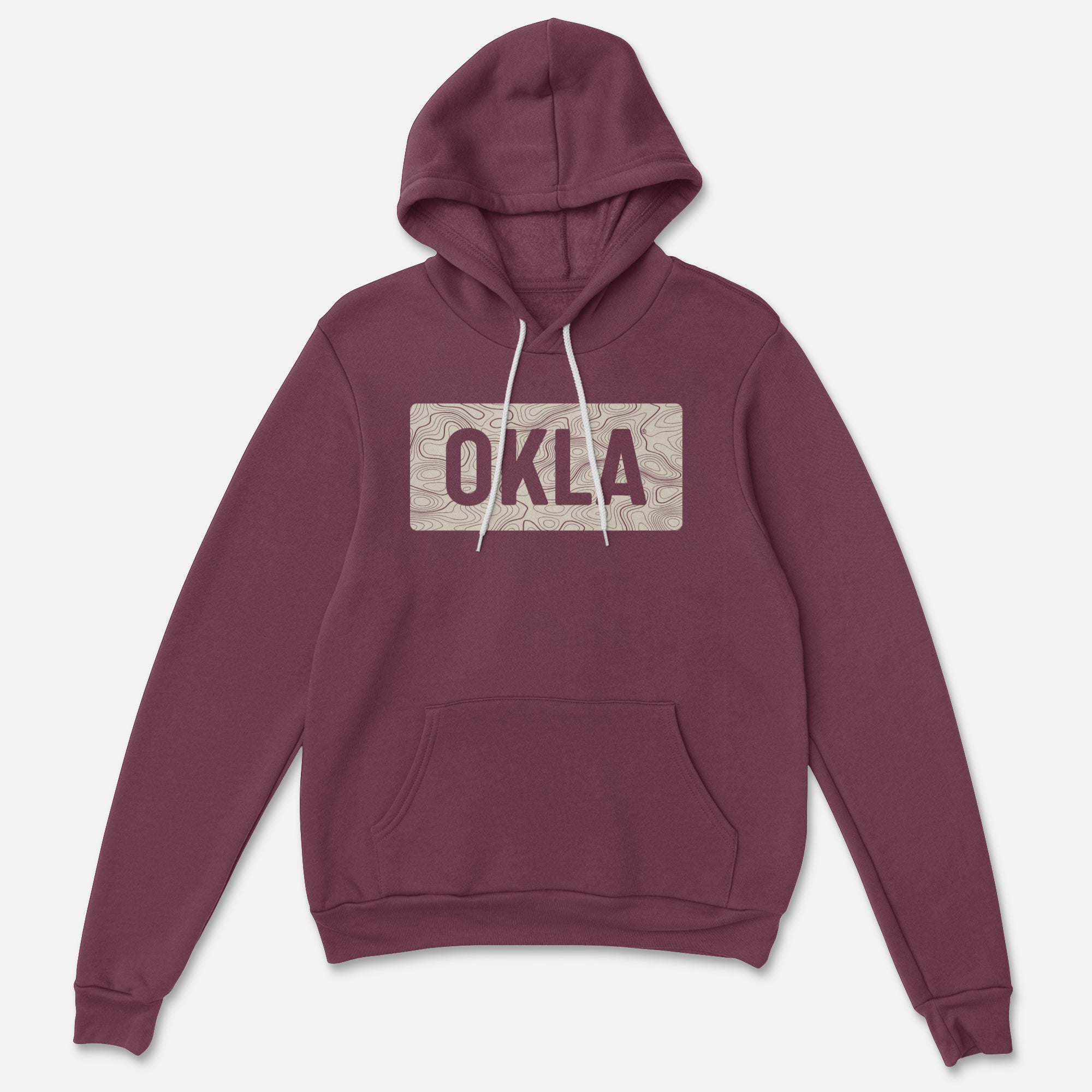 The OKLA Navigator BOLD Hoodie is a pullover made from recycled cotton, available in maroon. It features a front pocket and drawstrings and showcases a prominent rectangular design with the word "OKLA" on the chest, seamlessly merging adventure with comfort.