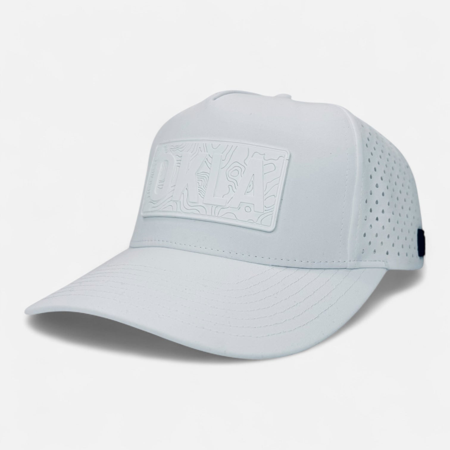 Introducing the OKLA Navigator Hat: This white baseball cap features a structured bill and a vintage-inspired 3D patch on the front. It includes small perforations on the sides for ventilation, and its sweat-wicking technology ensures maximum comfort. With a clean and modern aesthetic, it's perfect for any adventure.