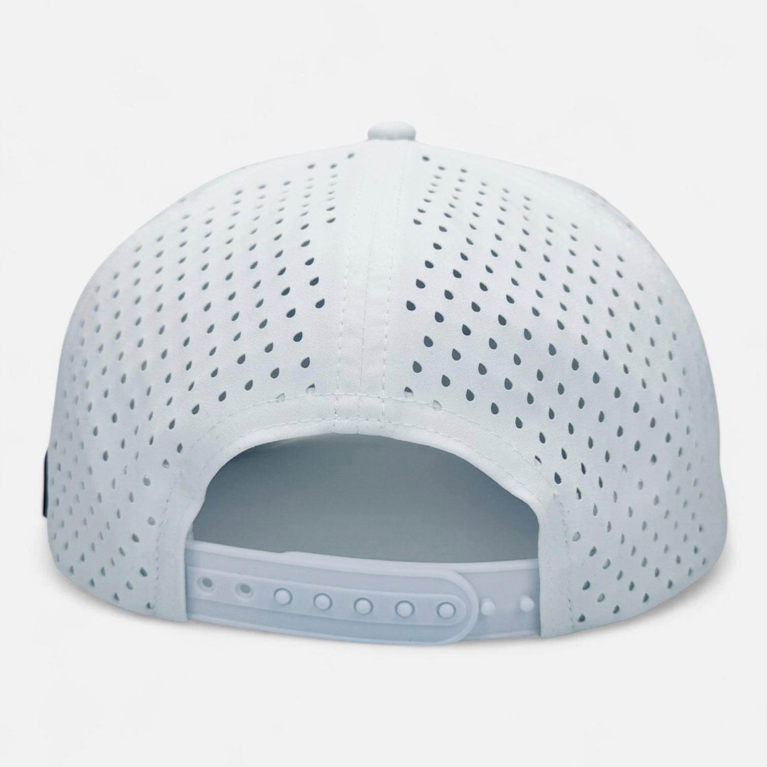 The OKLA Navigator Hat, showcased from the back, features a white perforated baseball design with sweat-wicking technology. It offers a snapback closure complete with multiple adjustment holes for a tailored fit. This vintage-inspired hat combines style and functionality seamlessly, highlighted by its 3D patch.