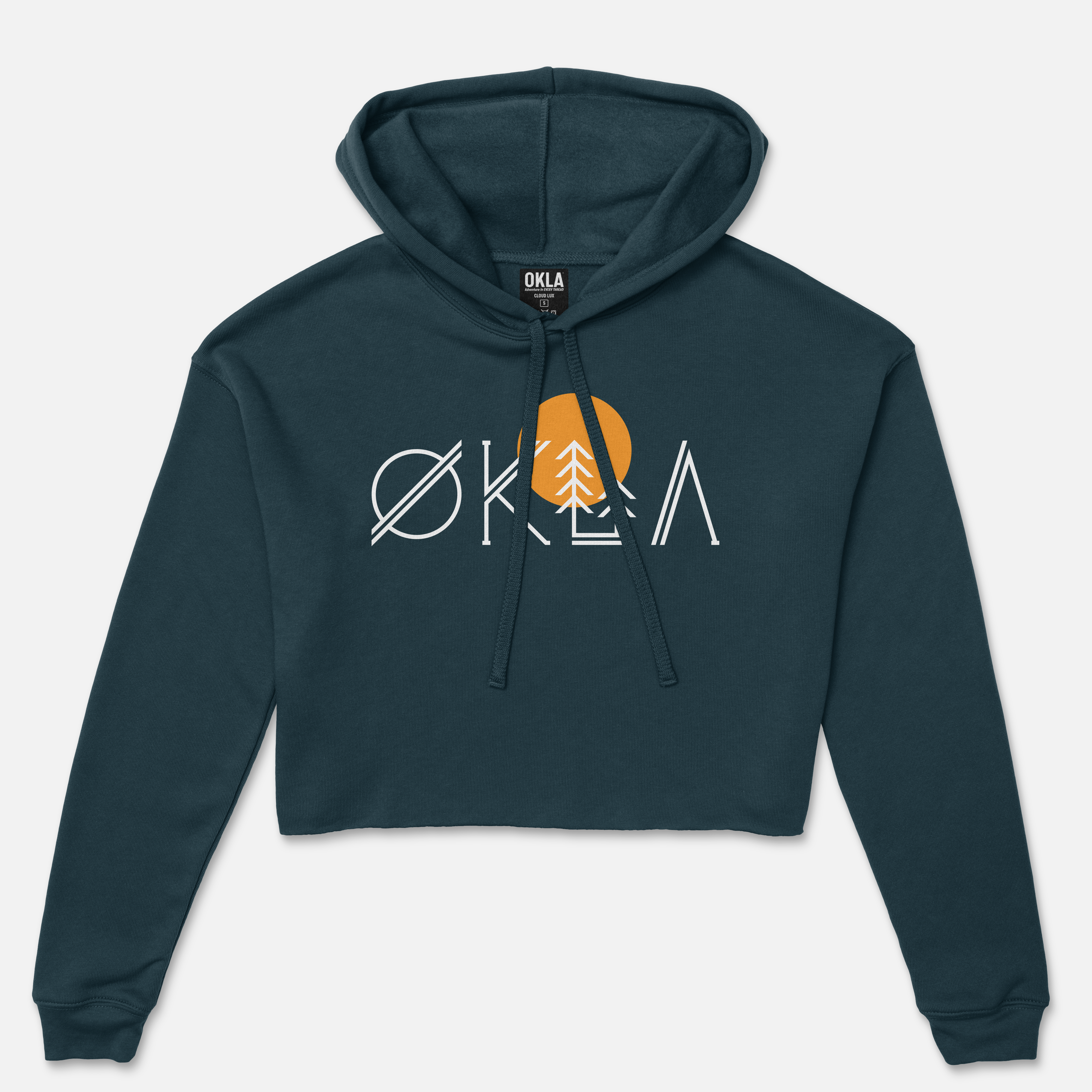 The OKLA Native Crop Hoodie is a dark teal fleece cropped hoodie that showcases the word "OKLA" in bold white letters with a unique tree design and an orange circle in the 'A'. This modern piece features a drawstring and is presented against a white background.