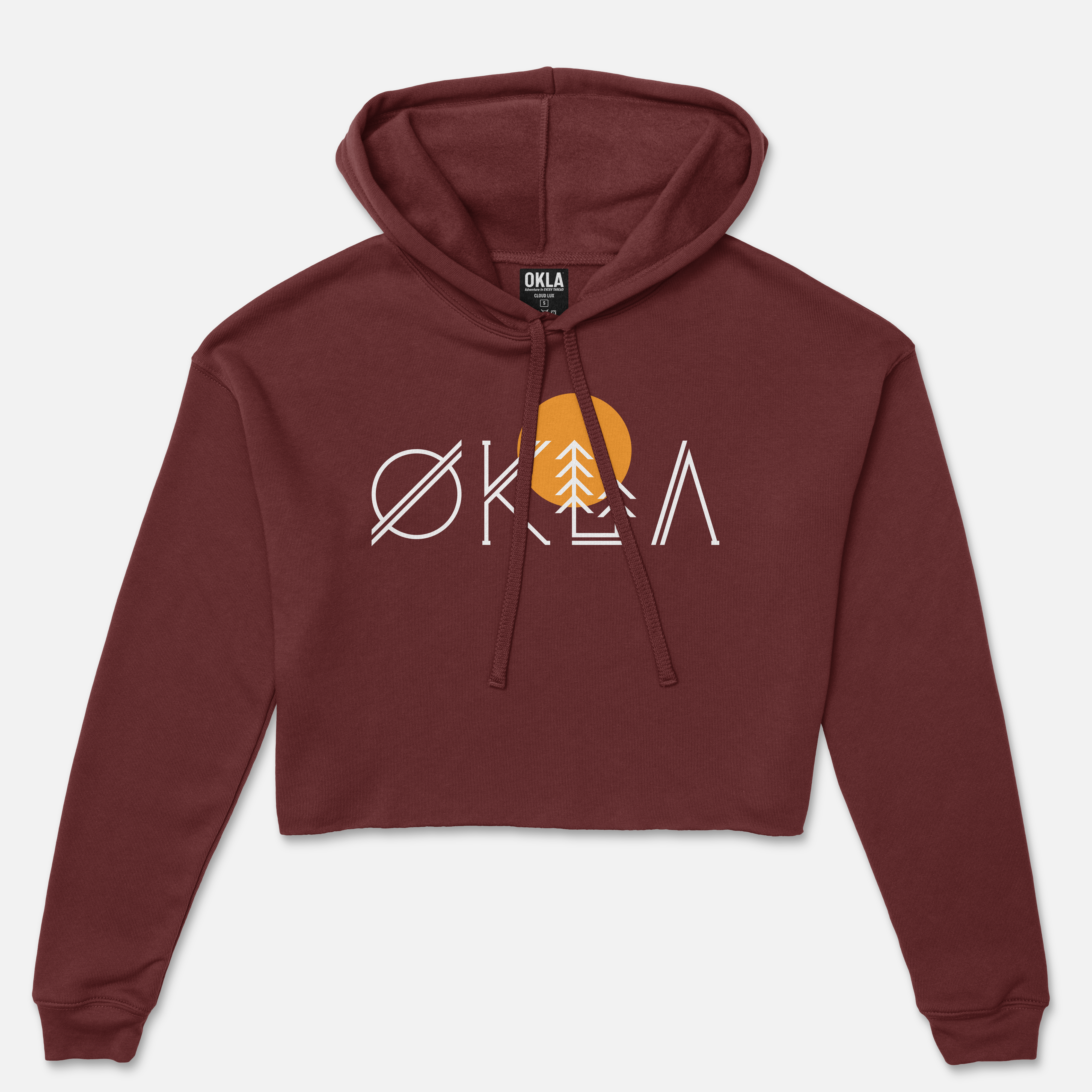 The OKLA Native Crop Hoodie is a maroon piece featuring a modern front design that creatively combines the word OKLA with a tree and sun graphic. Made from cozy fleece, it offers both style and comfort in one minimalist design.