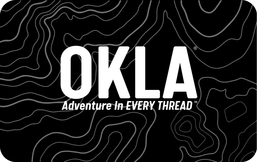 Bold white letters spell out "OKLA" against a black background with thin, wavy contour lines. Below this, smaller text reads "Adventure In EVERY THREAD." This design is featured on the OKLA Gift Card.