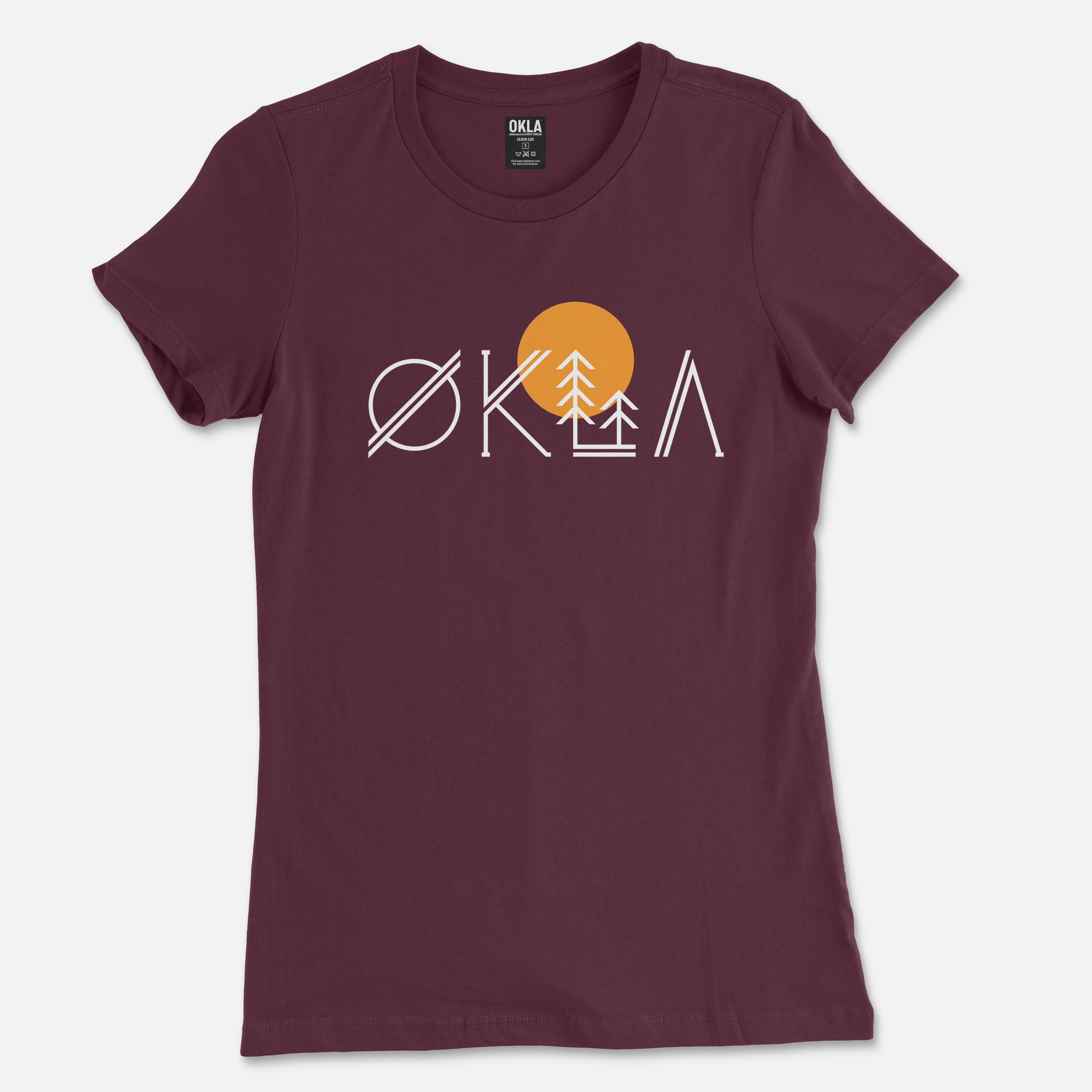 The OKLA Native Tee, available in a unisex fit, features a maroon color with a unique design. The logo includes a stylized OKLA where the O is crossed, and the A resembles a tree and sun icon for a nature-inspired look. Crafted from recycled cotton, it has the brand label inside the collar.