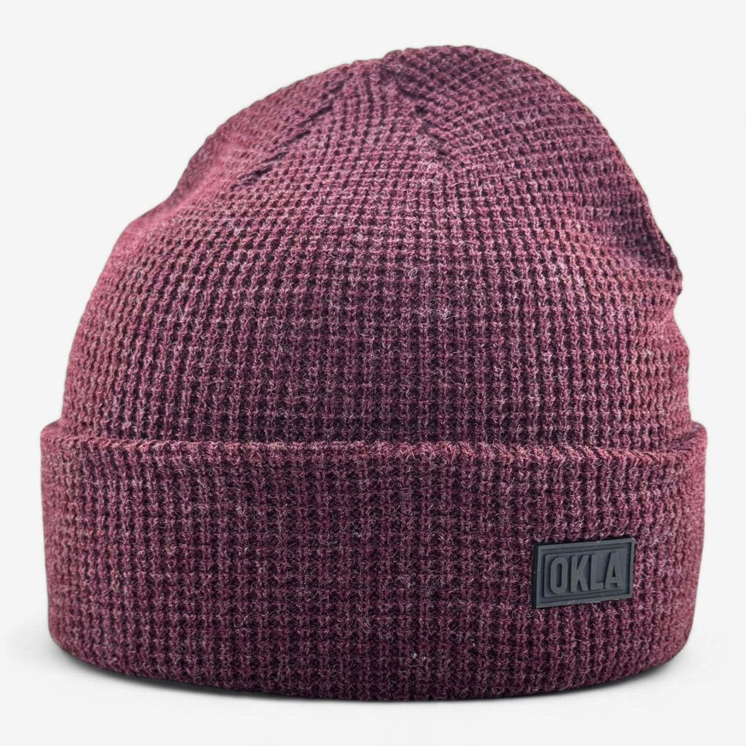 Introducing the OKLA Modern Beanie, a maroon waffle knit cuff with a folded brim and a distinctive small rectangular OKLA patch on the front. Its textured pattern and lightweight design combine to provide both warmth and style.