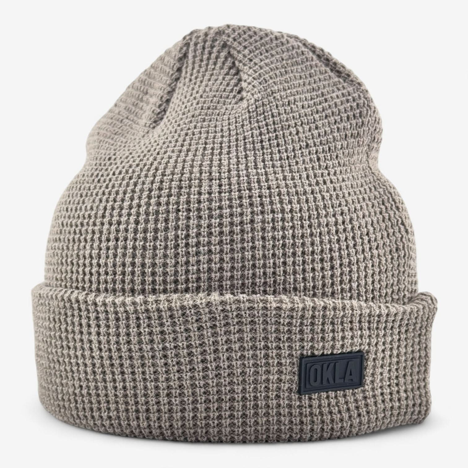 A textured gray OKLA Modern Beanie with a waffle knit cuff design and folded brim, featuring a small black patch labeled OKLA on the front. The distinctive knit pattern guarantees coziness and warmth while preserving its lightweight appeal, showcased against a plain white background.