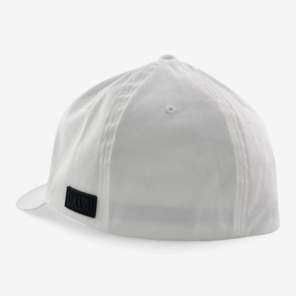 The white OKLA Original Fitted Hat features a black rectangular patch on the back. It boasts a smooth, unstructured design with a slightly curved visor and an elastic stretch band for comfort. The crisp white backdrop enhances the cap's clean aesthetics.