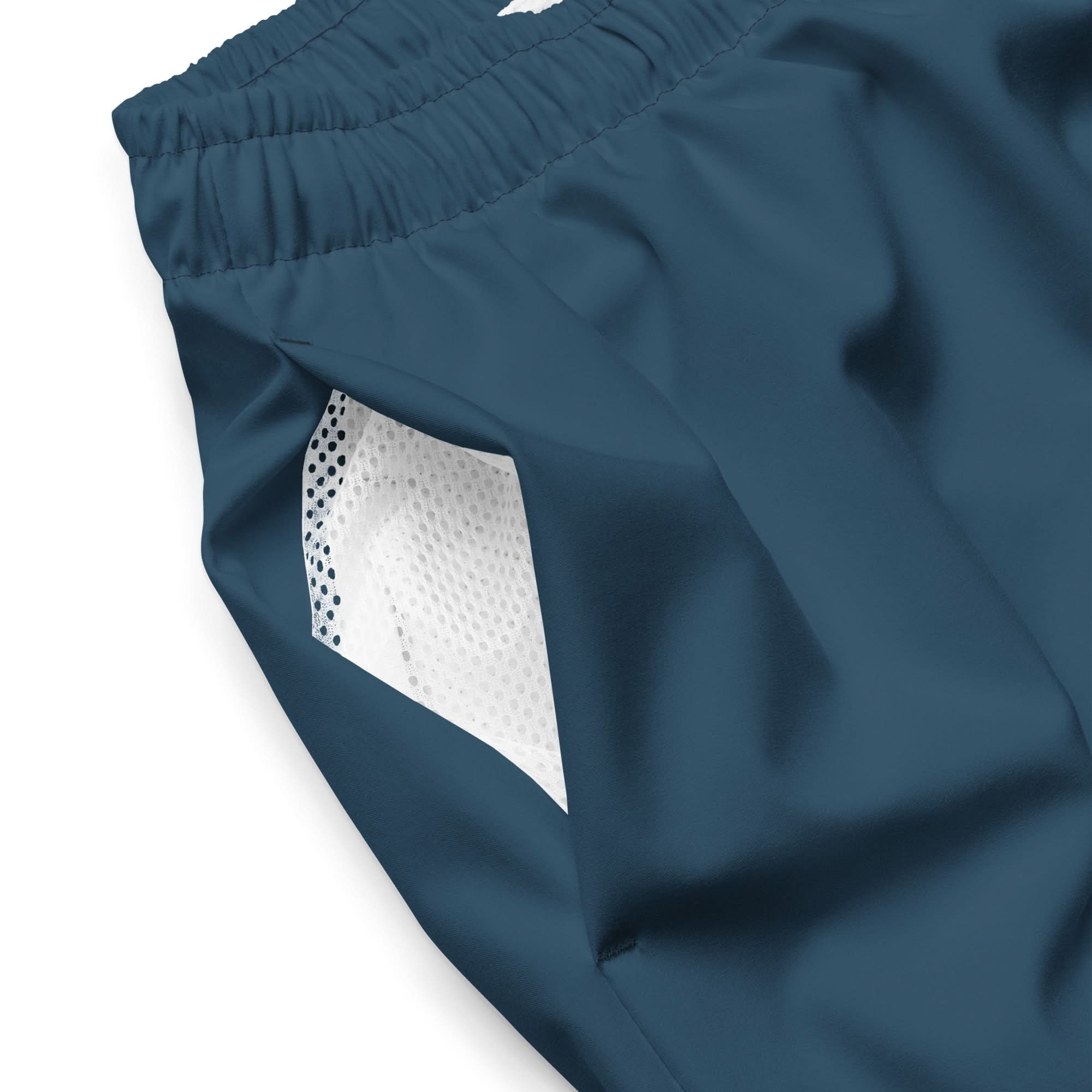 Close-up of blue OKLA Boardshorts featuring an elastic waistband and quick-drying design. The side displays a visible white mesh pocket lining, while the smooth, lightweight fabric is perfect for sports or casual wear.