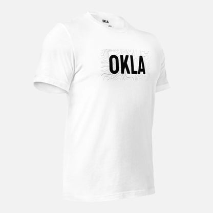 Explore the OKLA Navigator Tee, a white t-shirt made from recycled cotton for exceptional comfort. Featuring a bold 'OKLA' print and delicate map-like designs that suggest adventure, this tee merges style with sustainability effortlessly.